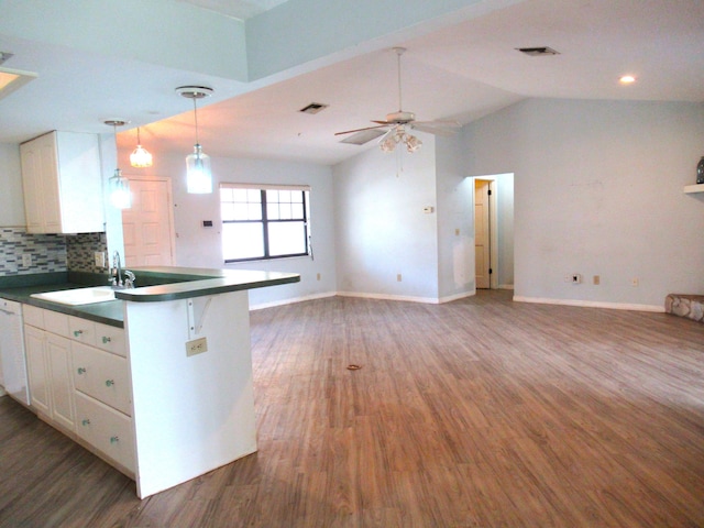 334 Brookedge Ter, Sebastian, FL 32958 - kitchen with dark countertops, white cabinets, a sink, wood finished floors, and vaulted ceiling