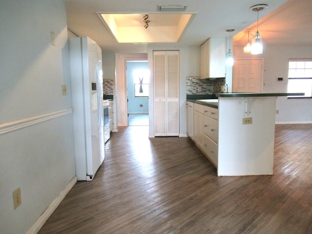 334 Brookedge Ter, Sebastian, FL 32958 - kitchen with white appliances, dark countertops, a peninsula, baseboards, and dark wood finished floors
