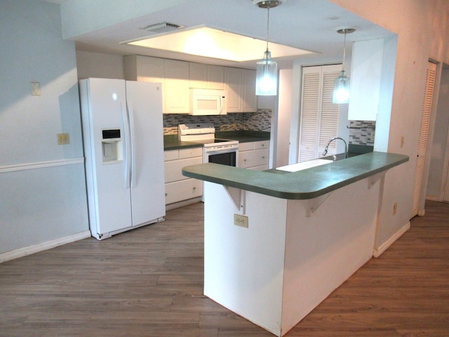 334 Brookedge Ter, Sebastian, FL 32958 - kitchen with white appliances, dark countertops, dark wood-type flooring, and a peninsula