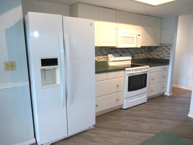 334 Brookedge Ter, Sebastian, FL 32958 - kitchen featuring white appliances, dark countertops, white cabinetry, light wood-type flooring, and backsplash