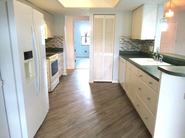 334 Brookedge Ter, Sebastian, FL 32958 - kitchen featuring white appliances, a sink, dark wood-type flooring, tasteful backsplash, and dark countertops