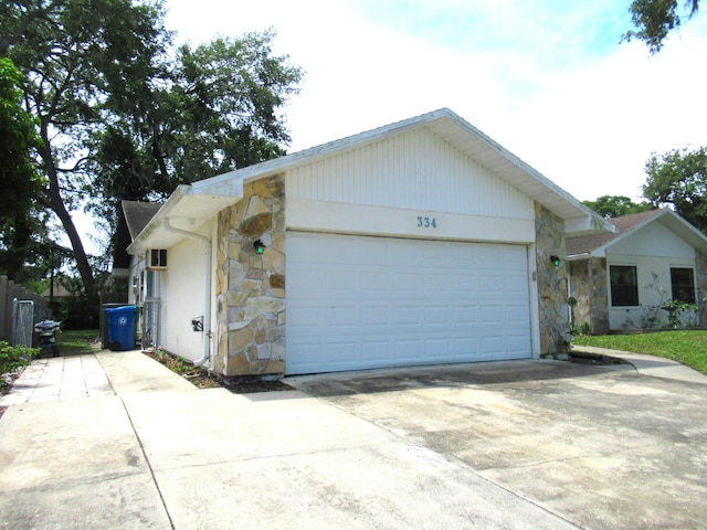 334 Brookedge Ter, Sebastian, FL 32958 - ranch-style house with stone siding, concrete driveway, and an attached garage