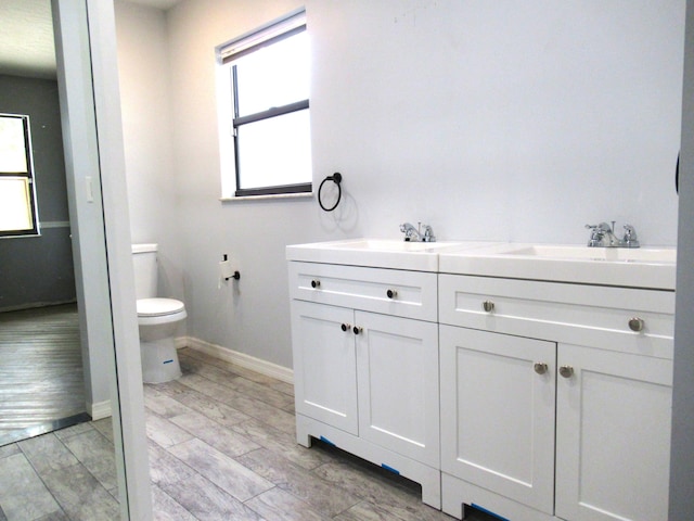 334 Brookedge Ter, Sebastian, FL 32958 - bathroom with toilet, baseboards, double vanity, and wood finish floors