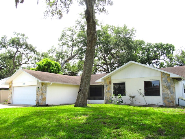 334 Brookedge Ter, Sebastian, FL 32958 - ranch-style house featuring stone siding, a garage, a front yard, concrete driveway, and a shingled roof