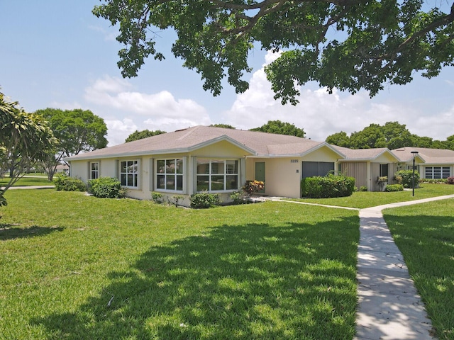 5229 Lakefront Blvd Unit A, Delray Beach, FL 33484 - ranch-style home with a front yard, an attached garage, and stucco siding