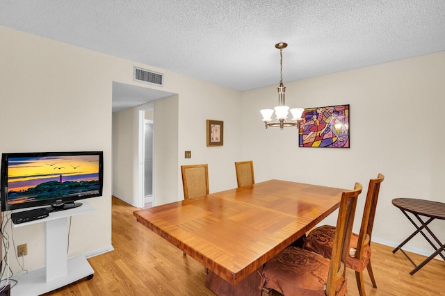 5229 Lakefront Blvd Unit A, Delray Beach, FL 33484 - dining area featuring light wood-style floors, a chandelier, and a textured ceiling