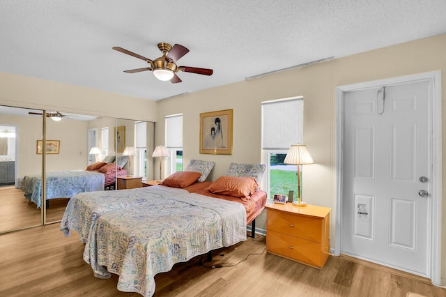 5229 Lakefront Blvd Unit A, Delray Beach, FL 33484 - bedroom with multiple windows, wood finished floors, a closet, a ceiling fan, and a textured ceiling