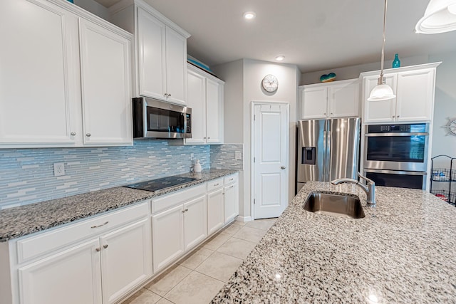 9351 SW Serapis Way, Port Saint Lucie, FL 34987 - kitchen featuring appliances with stainless steel finishes, a sink, light tile patterned flooring, white cabinetry, and recessed lighting
