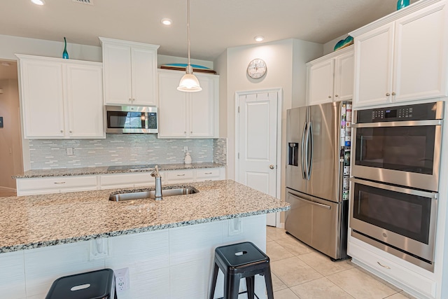 9351 SW Serapis Way, Port Saint Lucie, FL 34987 - kitchen featuring appliances with stainless steel finishes, a sink, a kitchen bar, white cabinets, and recessed lighting