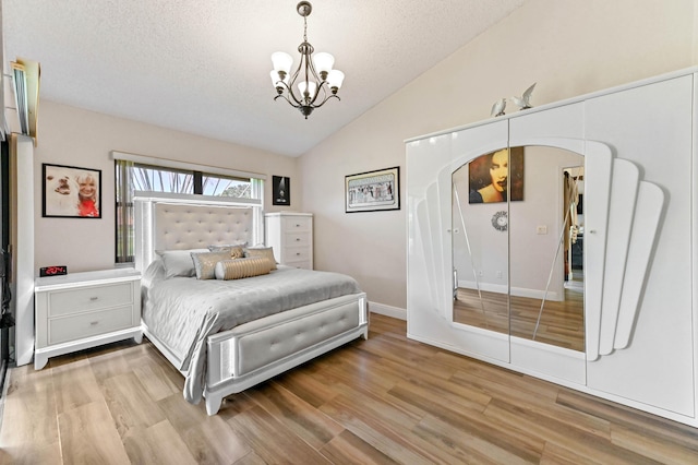 8178 Mooring Cir, Boynton Beach, FL 33472 - bedroom with a chandelier, vaulted ceiling, wood finished floors, arched walkways, and a textured ceiling