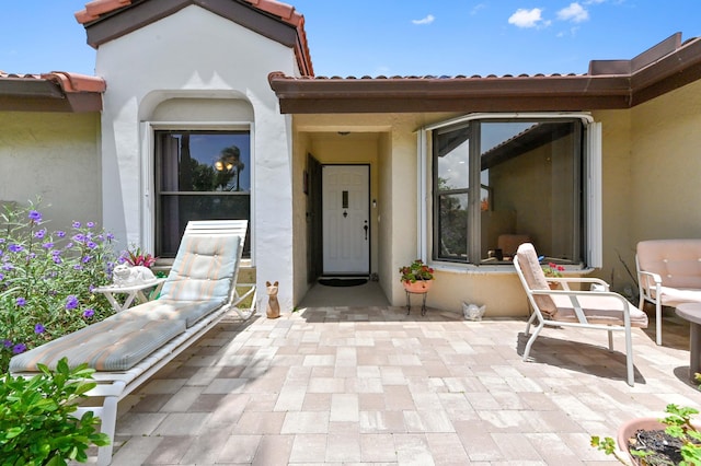 8178 Mooring Cir, Boynton Beach, FL 33472 - doorway to property with stucco siding, a tiled roof, and a patio area