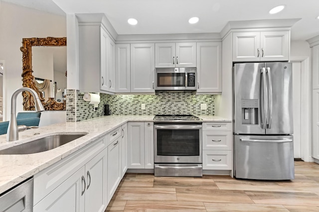 8178 Mooring Cir, Boynton Beach, FL 33472 - kitchen featuring appliances with stainless steel finishes, a sink, light stone countertops, tasteful backsplash, and white cabinetry