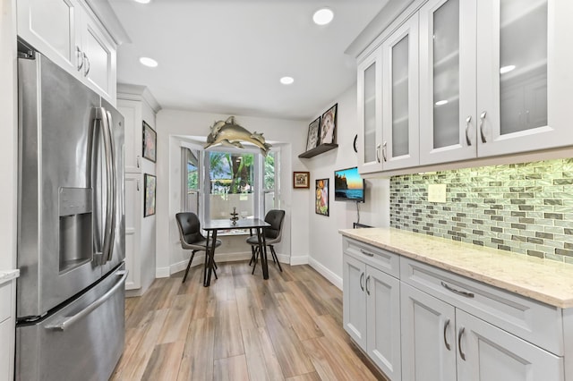 8178 Mooring Cir, Boynton Beach, FL 33472 - kitchen featuring stainless steel fridge with ice dispenser, tasteful backsplash, light wood-type flooring, baseboards, and light stone counters