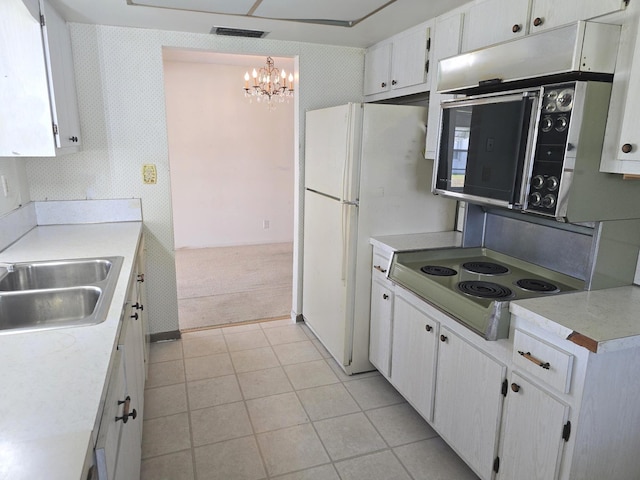 1003 SW 7th Ave, Boynton Beach, FL 33426 - kitchen featuring a chandelier, light carpet, light countertops, a sink, and white cabinetry