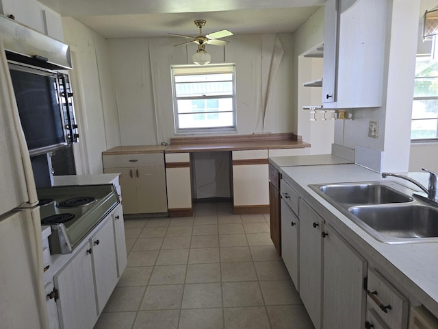 1003 SW 7th Ave, Boynton Beach, FL 33426 - kitchen with a sink, freestanding refrigerator, white cabinets, light tile patterned floors, and ceiling fan