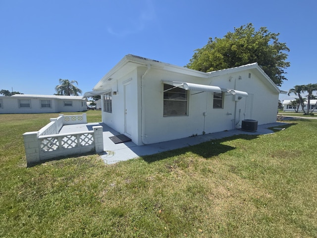 1003 SW 7th Ave, Boynton Beach, FL 33426 - view of side of home with a yard, central AC unit, and stucco siding