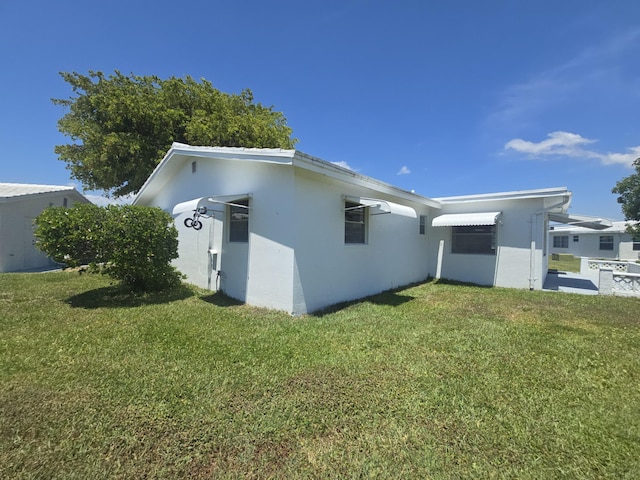 1003 SW 7th Ave, Boynton Beach, FL 33426 - view of home's exterior featuring a lawn and stucco siding
