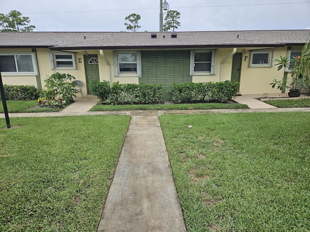2941 Crrosley Dr W Unit E, West Palm Beach, FL 33415 - ranch-style house featuring a front yard, stucco siding, and a shingled roof
