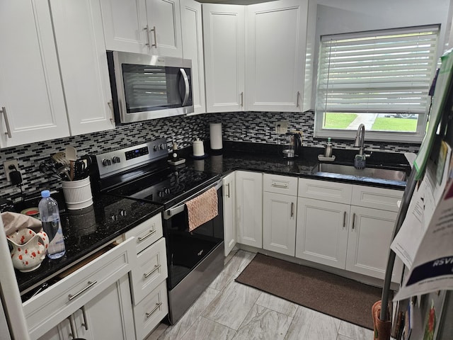 2941 Crrosley Dr W Unit E, West Palm Beach, FL 33415 - kitchen with stainless steel appliances, a sink, backsplash, white cabinetry, and dark stone counters