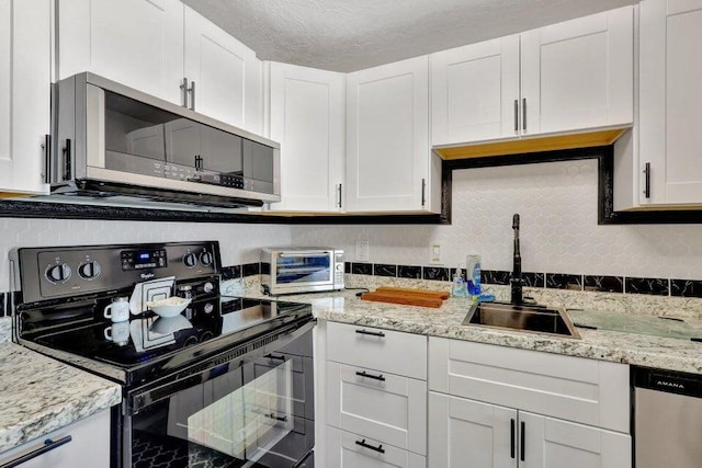 278 Monaco Way Unit F, Delray Beach, FL 33446 - kitchen with appliances with stainless steel finishes, a sink, white cabinetry, light stone counters, and a textured ceiling