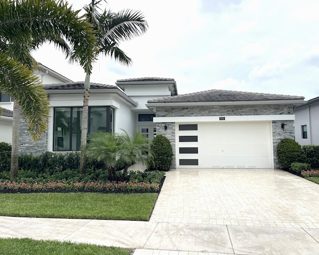 9072 Benedetta Pl, Boca Raton, FL 33496 - prairie-style home with stone siding, decorative driveway, an attached garage, stucco siding, and a front yard
