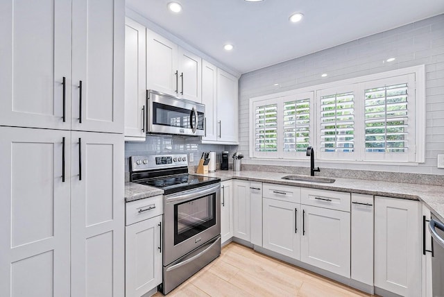 215 Cortez Rd, West Palm Beach, FL 33405 - kitchen featuring stainless steel appliances, a sink, recessed lighting, white cabinets, and light stone countertops