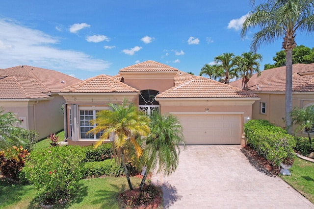 7144 Demedici Cir, Delray Beach, FL 33446 - mediterranean / spanish home with a garage, decorative driveway, a tile roof, and stucco siding