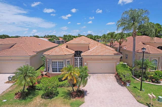 7144 Demedici Cir, Delray Beach, FL 33446 - mediterranean / spanish house with an attached garage, decorative driveway, stucco siding, and a tile roof