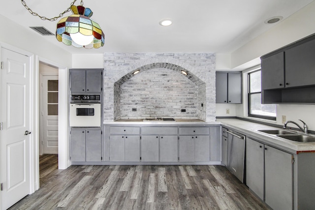 5666 SE Matousek St, Stuart, FL 34997 - kitchen featuring oven, a sink, gray cabinetry, stainless steel dishwasher, and cooktop