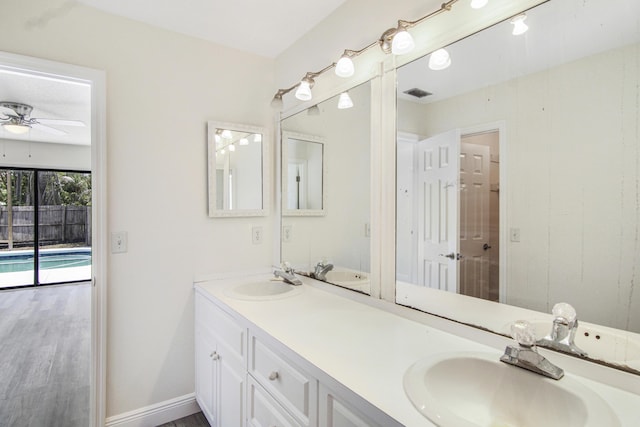 5666 SE Matousek St, Stuart, FL 34997 - full bathroom with a ceiling fan, double vanity, and wood finished floors