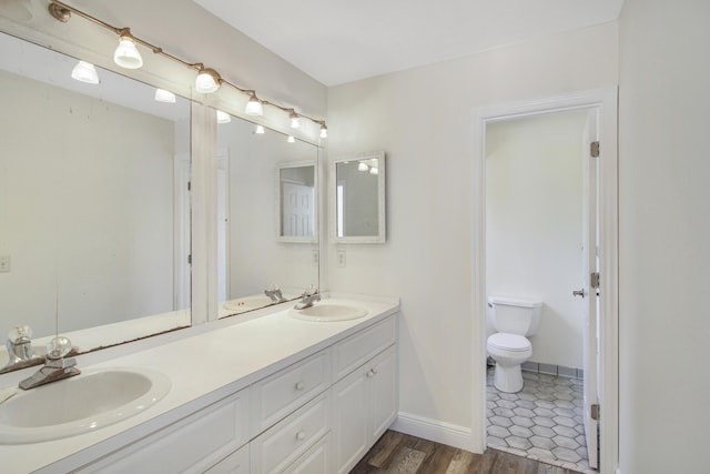 5666 SE Matousek St, Stuart, FL 34997 - full bathroom with double vanity, toilet, baseboards, and wood finished floors