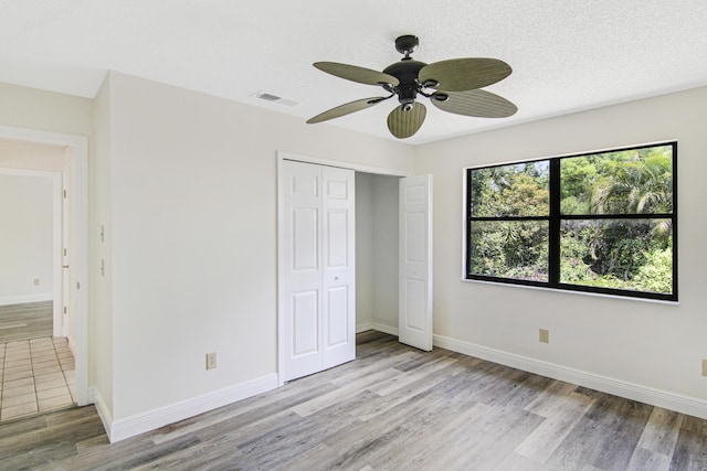 5666 SE Matousek St, Stuart, FL 34997 - unfurnished bedroom with light wood-type flooring, a closet, baseboards, and ceiling fan