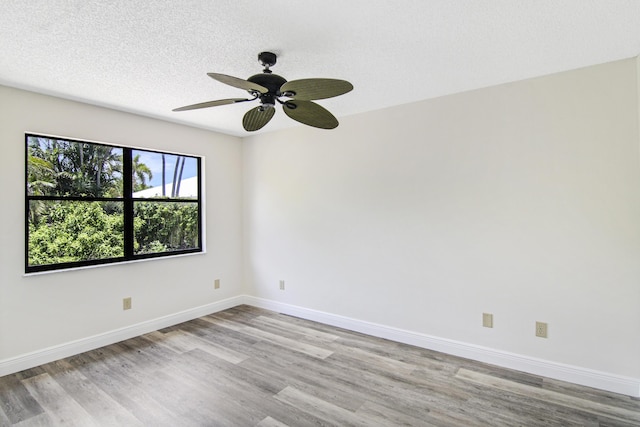 5666 SE Matousek St, Stuart, FL 34997 - unfurnished room featuring light wood-style flooring, baseboards, ceiling fan, and a textured ceiling