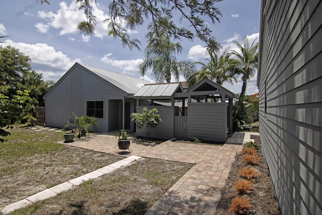 5666 SE Matousek St, Stuart, FL 34997 - view of front facade with a patio and metal roof