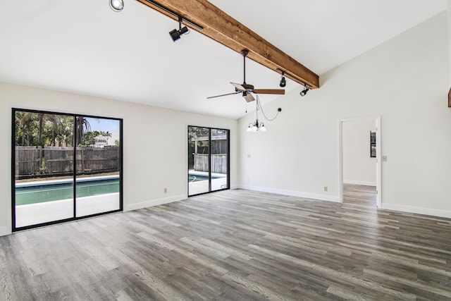 5666 SE Matousek St, Stuart, FL 34997 - empty room with rail lighting, healthy amount of natural light, wood finished floors, beamed ceiling, and high vaulted ceiling
