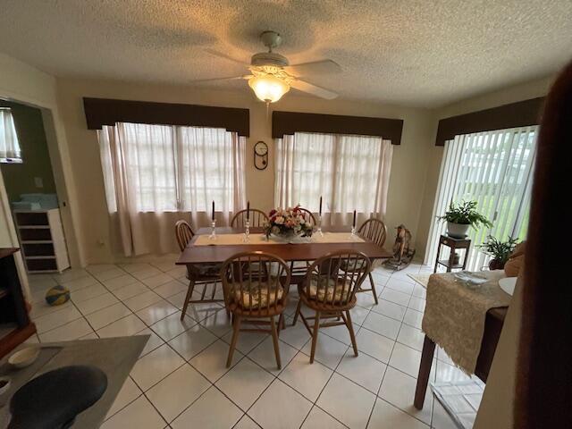 108 SW 18th St, Boynton Beach, FL 33426 - dining space featuring a textured ceiling, healthy amount of natural light, a ceiling fan, and light tile patterned floors