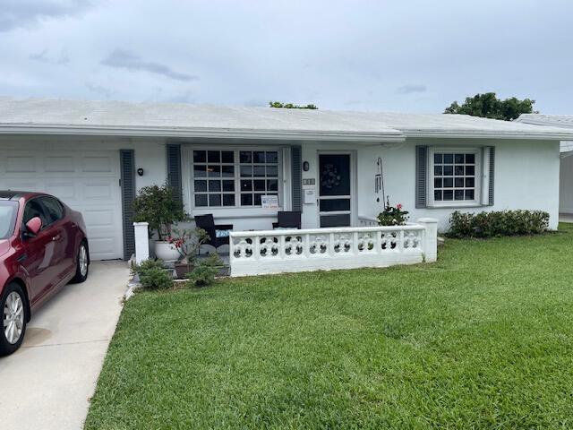 108 SW 18th St, Boynton Beach, FL 33426 - single story home featuring a porch, a garage, a front lawn, and stucco siding