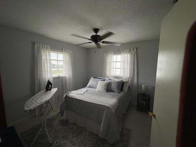 108 SW 18th St, Boynton Beach, FL 33426 - bedroom featuring multiple windows, a ceiling fan, a textured ceiling, and baseboards