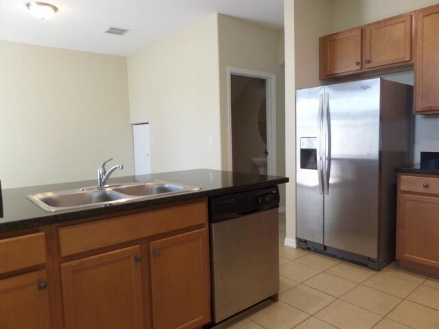 328 Lake Monterey Cir, Boynton Beach, FL 33426 - kitchen featuring stainless steel appliances, a sink, dark countertops, light tile patterned flooring, and brown cabinets
