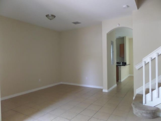 328 Lake Monterey Cir, Boynton Beach, FL 33426 - spare room with stairs, light tile patterned floors, and arched walkways