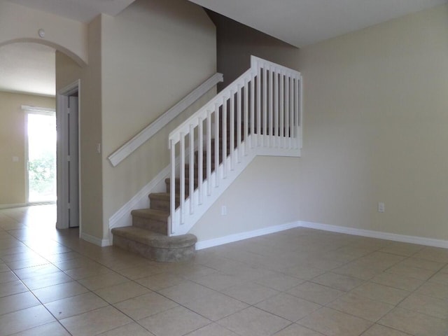 328 Lake Monterey Cir, Boynton Beach, FL 33426 - stairs with tile patterned floors, arched walkways, and baseboards