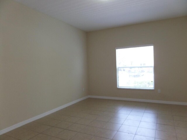328 Lake Monterey Cir, Boynton Beach, FL 33426 - empty room with light tile patterned floors and baseboards