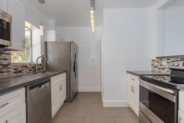 1715 12th Ave N, Lake Worth Beach, FL 33460 - kitchen featuring stainless steel appliances, backsplash, white cabinetry, and dark stone counters