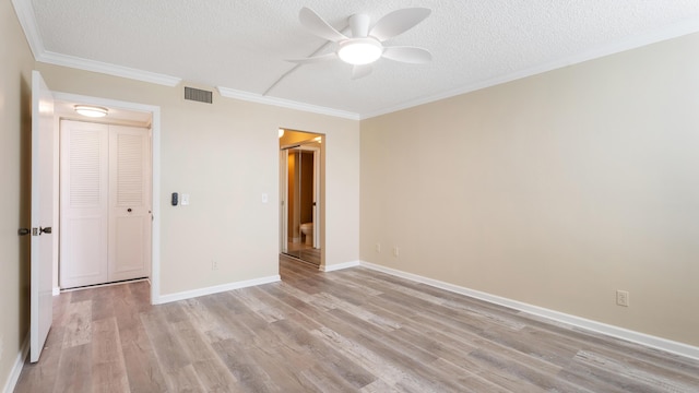 1950 SW Palm City Rd Unit 8302, Stuart, FL 34994 - unfurnished bedroom with a textured ceiling, light wood-style flooring, crown molding, baseboards, and a ceiling fan