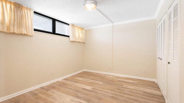 1950 SW Palm City Rd Unit 8302, Stuart, FL 34994 - unfurnished bedroom with a textured ceiling, a closet, light wood finished floors, baseboards, and ornamental molding