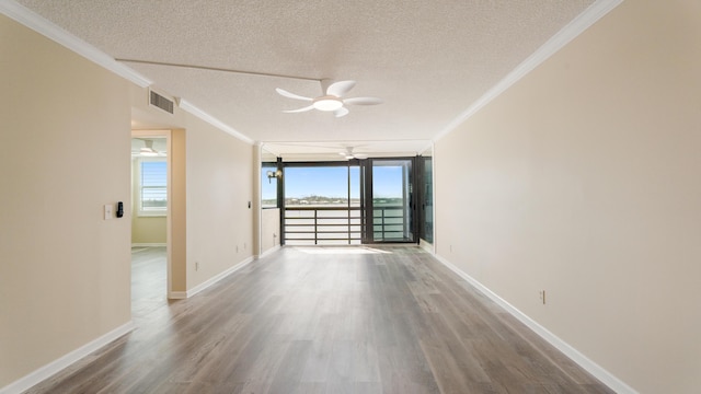 1950 SW Palm City Rd Unit 8302, Stuart, FL 34994 - unfurnished room featuring a ceiling fan, a textured ceiling, crown molding, wood finished floors, and baseboards
