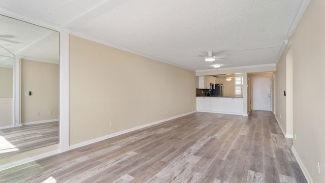 1950 SW Palm City Rd Unit 8302, Stuart, FL 34994 - unfurnished living room with a ceiling fan, light wood-type flooring, crown molding, a textured ceiling, and baseboards