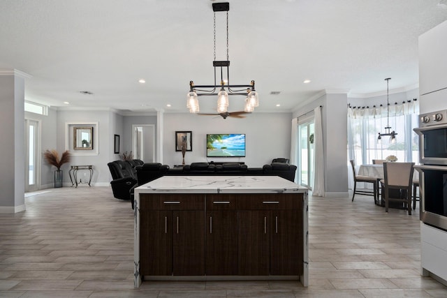 979 SW Mcdevitt Ave, Port Saint Lucie, FL 34953 - kitchen featuring open floor plan, a chandelier, light wood finished floors, dark brown cabinets, and recessed lighting