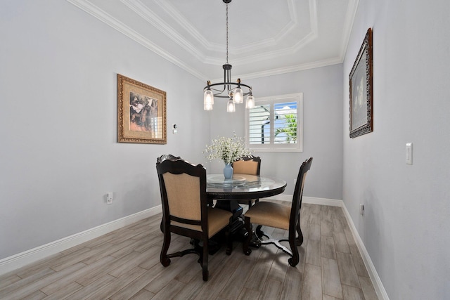 979 SW Mcdevitt Ave, Port Saint Lucie, FL 34953 - dining space featuring a chandelier, light wood-type flooring, a raised ceiling, baseboards, and ornamental molding