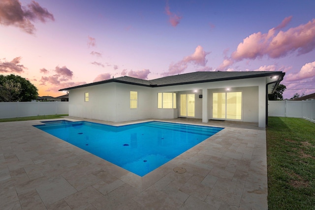 979 SW Mcdevitt Ave, Port Saint Lucie, FL 34953 - pool at dusk featuring a patio area and a fenced backyard